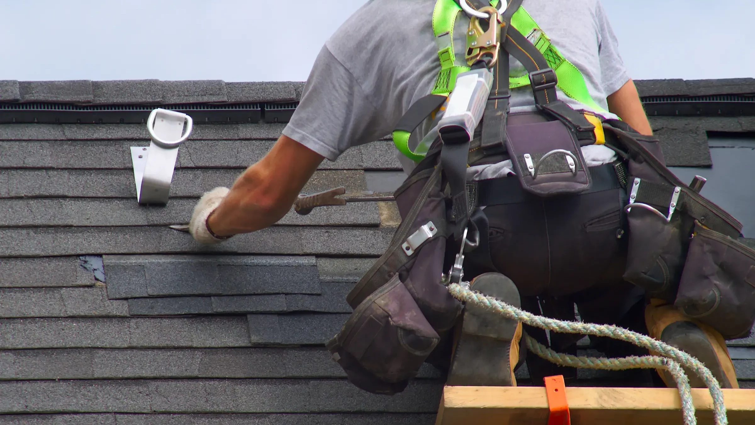 Artisan en tenue de travail en train de réparer un toit