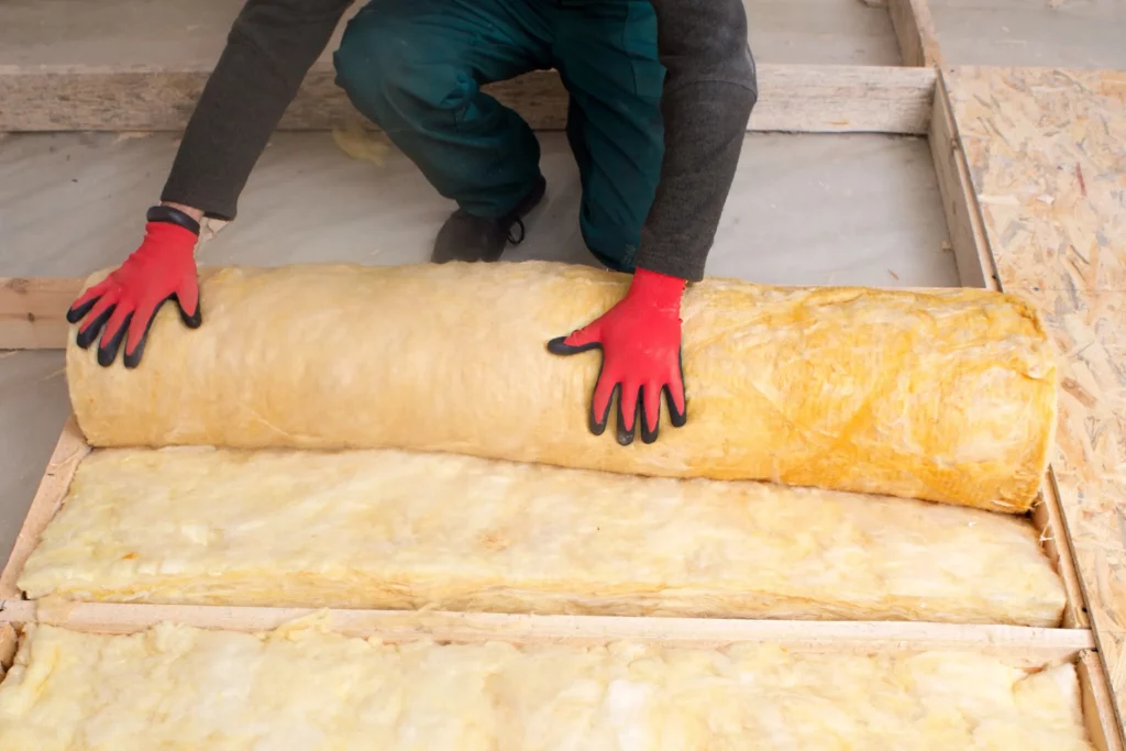 Pose de rouleau d'isolant par un artisan
